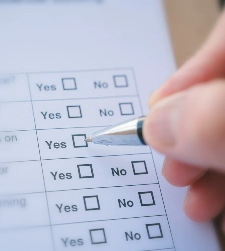 Hand marking a&nbsp;‘Yes’ checkbox on a&nbsp;printed survey form