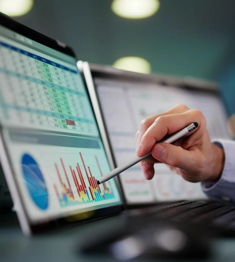 erson analyzing data on a&nbsp;tablet with bar charts, a&nbsp;pie chart, and a&nbsp;numeric spreadsheet